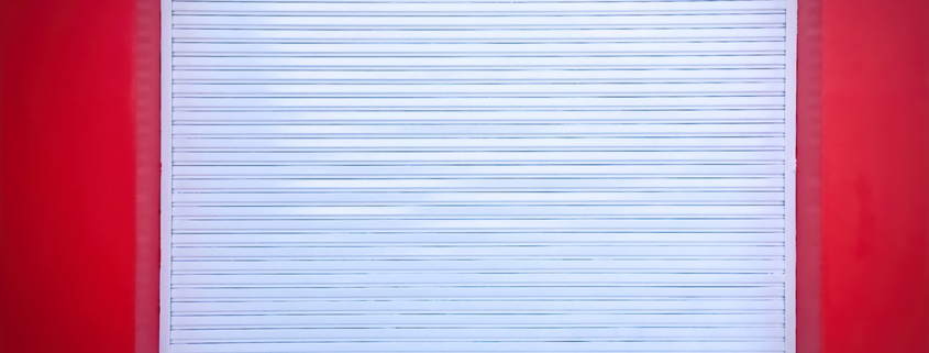 White Roll-up Door on Red Wall of the Garage